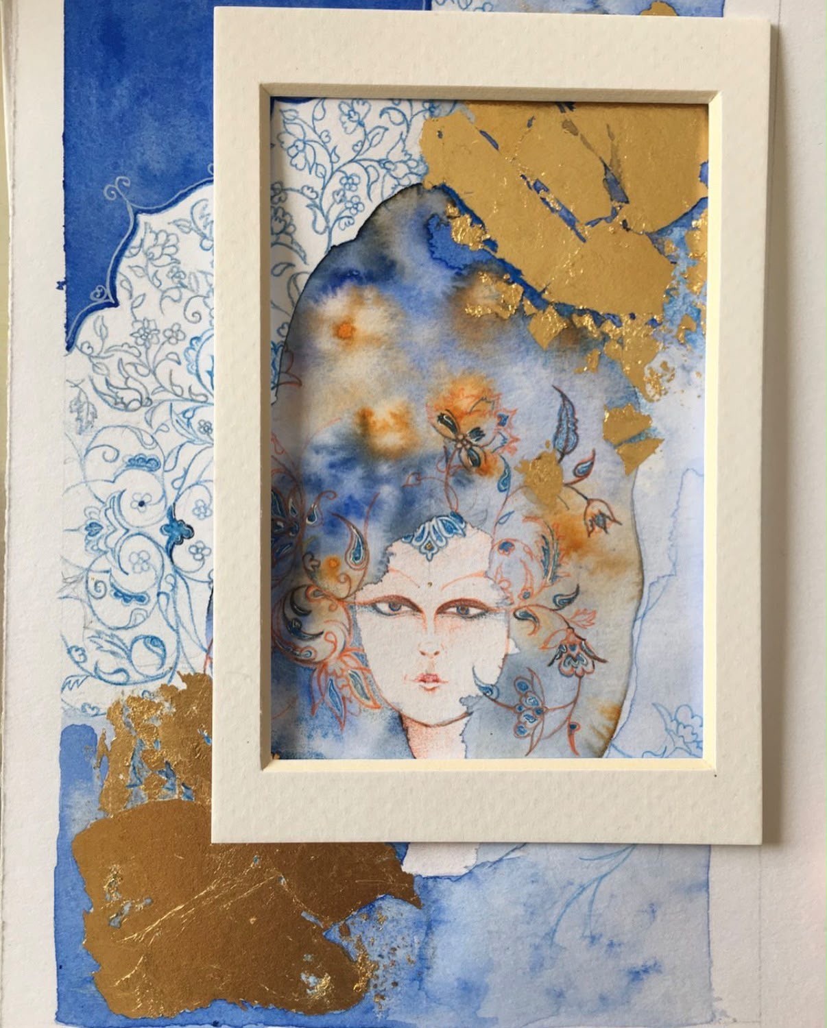 Framed portrait surrounded by blue floral ornament and gold
