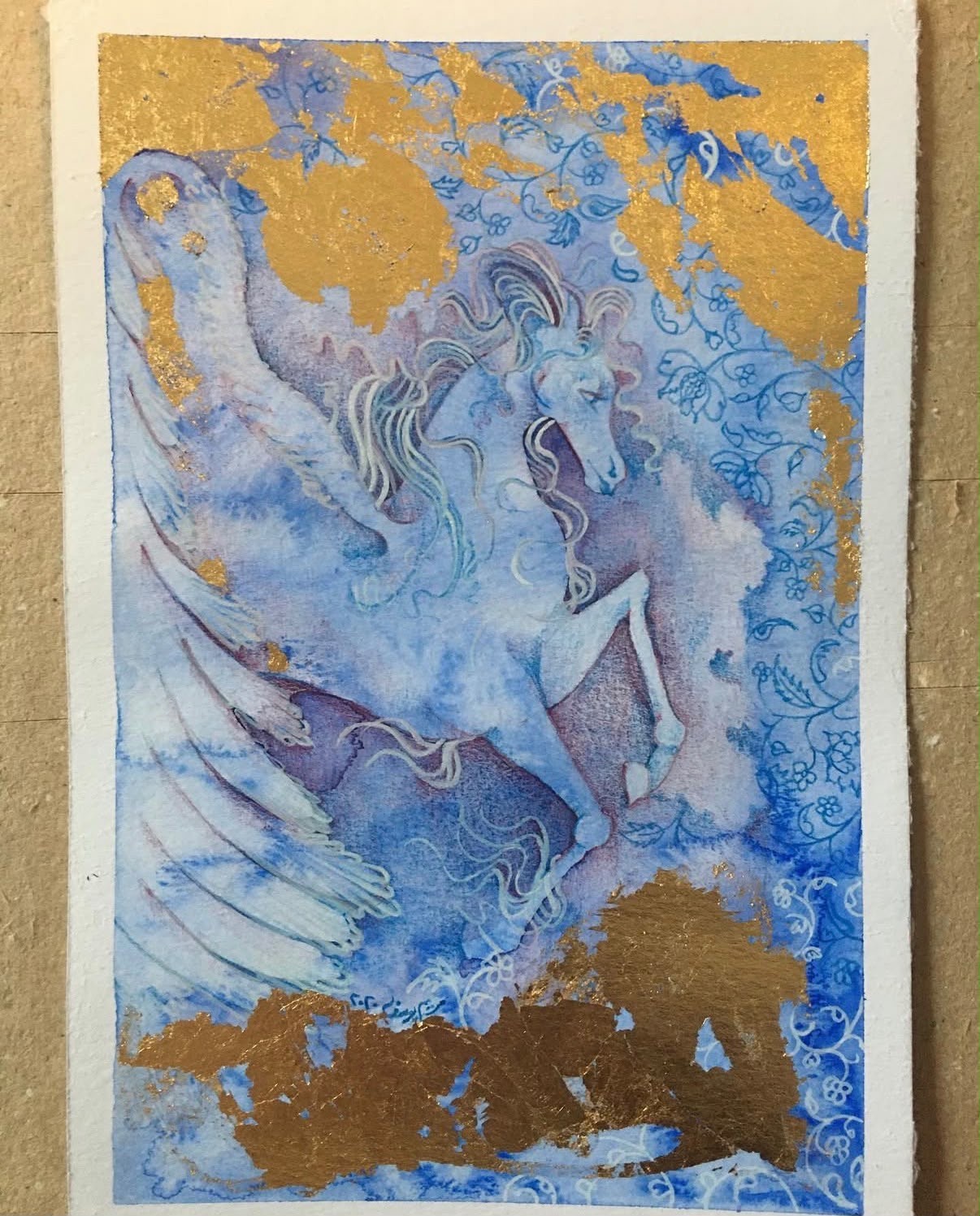 Pale blue winged horse with floral patterns and gold accents